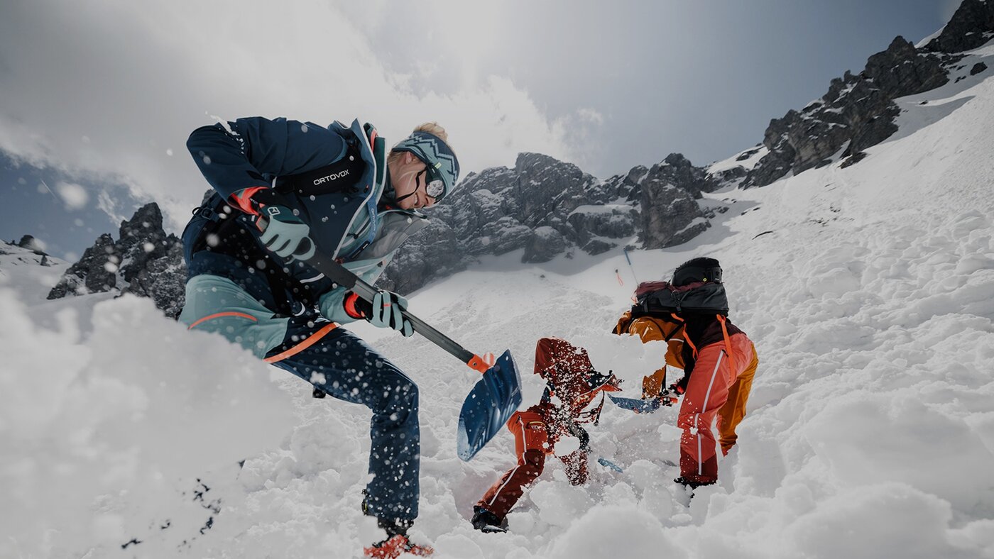 avalanche courses in the snow with three people using shovels and probes